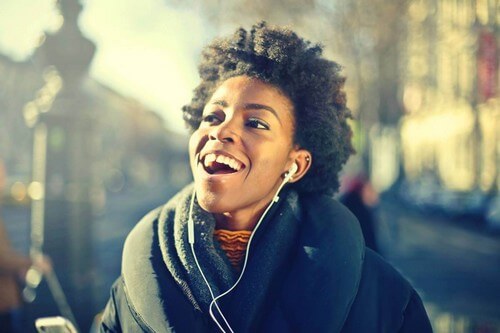 Ragazza sorridente che ascolta la musica.