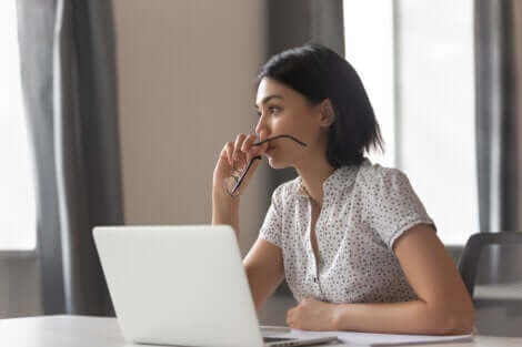 Ragazza dubbiosa davanti al computer di lavoro.