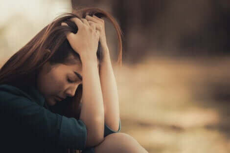 Ragazza triste con le mani sulla testa.