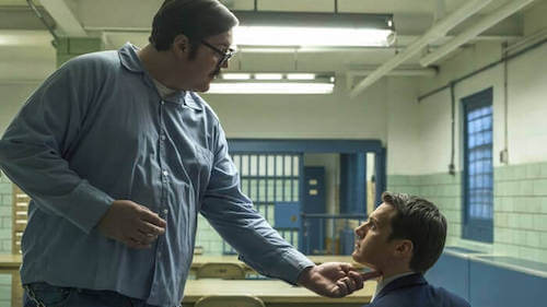 Poliziotto che interroga un detenuto.