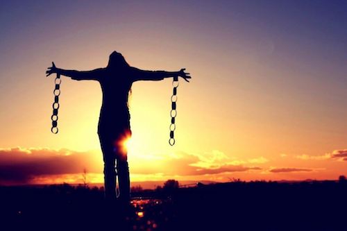 Donna libera dalle catene che apre le braccia al mondo.