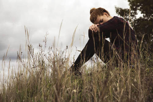 Donna triste che pensa da sola in un parco.