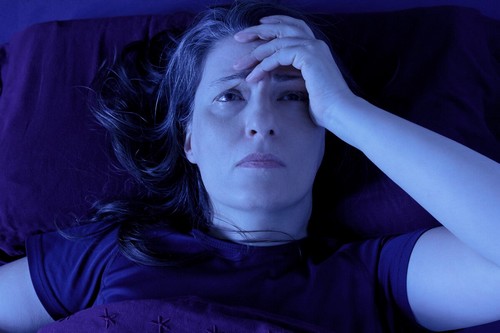 Donna che non riesce a dormire per il dolore cronico.