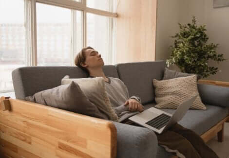 Ragazzo addormentato con il pc sulle gambe.