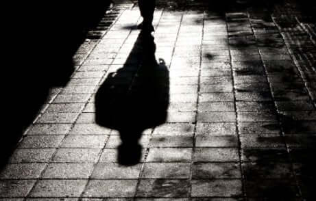 Ombra di uomo che cammina in un vicolo buio.