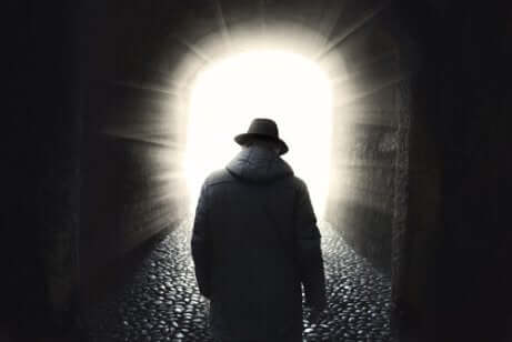 Uomo di spalle si incammina verso la luce.