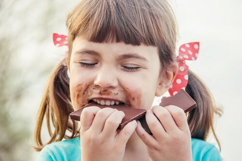 Bambina che mangia il cioccolato.