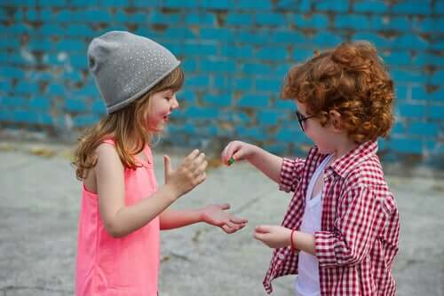 Bambino che regala una caramella ad una sua amica.