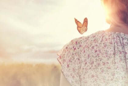 Farfalla sulla spalla di una donna.