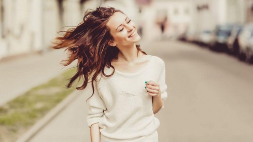 Donna felice che cammina per strada.