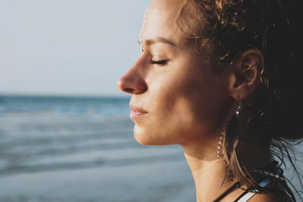 Donna con gli occhi chiusi vicina al mare