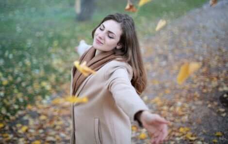 Ragazza felice circondata di foglie.