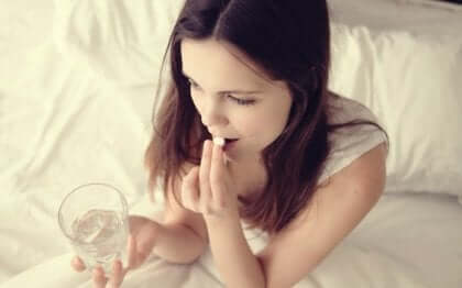 Ragazza che ingerisce una pillola.