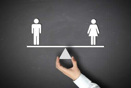 Uomo e donna su una bilancia in equilibrio e la teoria dello schema di genere.