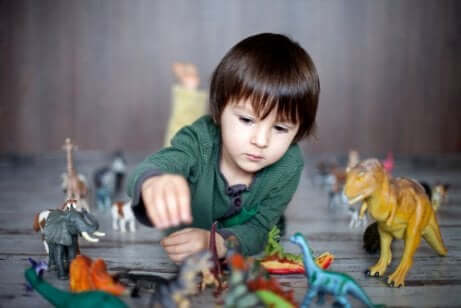 Bambino che gioca con i dinosauri.