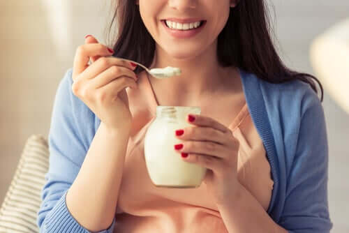 Donna che mangia uno yogurt.