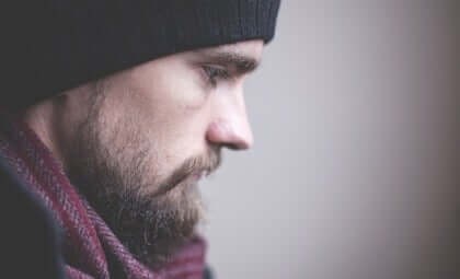 Ragazzo con barba e sguardo triste.