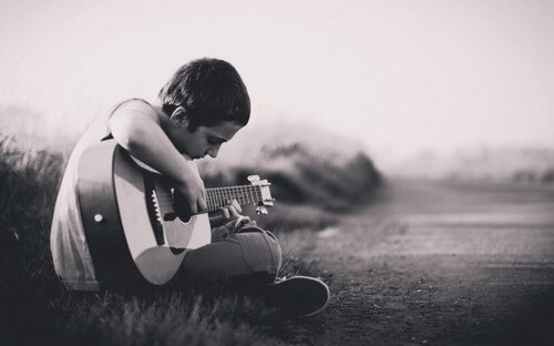 Ragazzino che suona la chitarra.