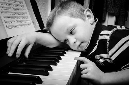 Bambino triste al pianoforte.
