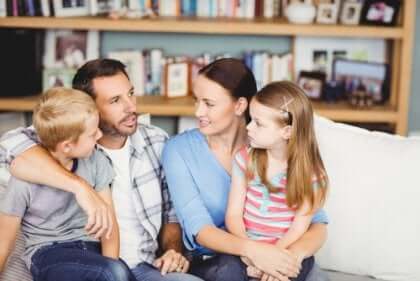 Essere genitori: famiglia parla seduta sul divano.