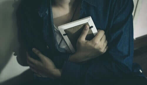 Donna che tiene tra le mani luna foto del padre scomparso.