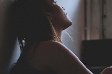 Depressione e colore grigio, donna seduta al buio.