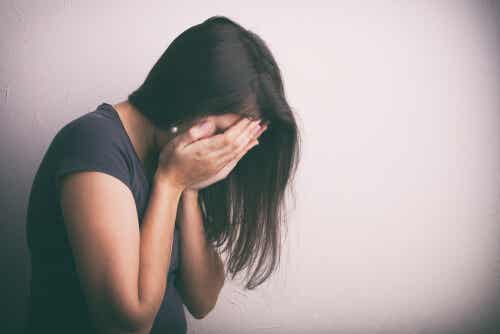 Ragazza triste si copre il volto.