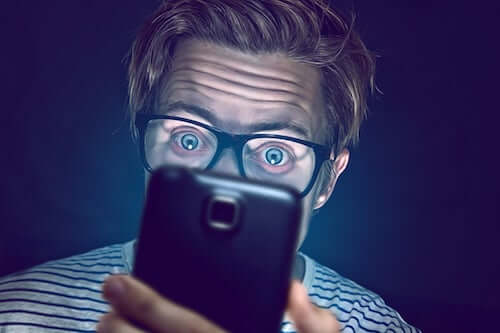 Uomo che guarda lo schermo del telefono.