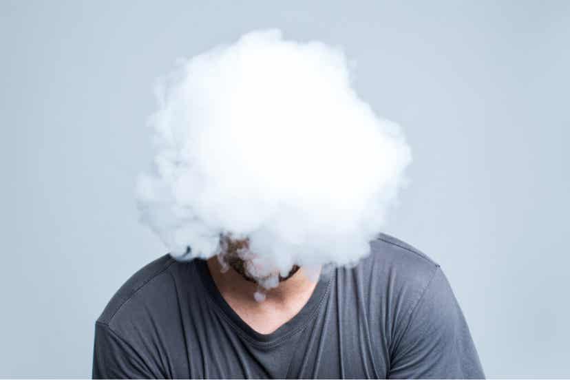 Paralisi della perfezione rappresentata da un uomo con testa dentro una nuvola.