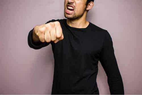 Uomo aggressivo che mostra il pugno.