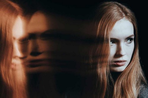 Donna riflessa allo specchio.