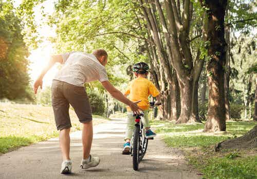 Padre che insegna al figlio ad andare in bicicletta.