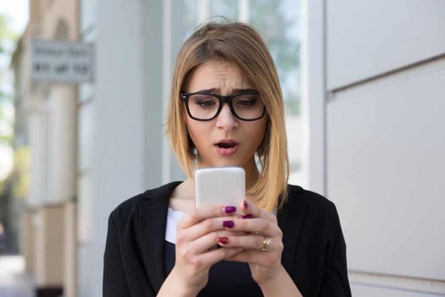 Donna che guarda il cellulare e più felici senza i social network.