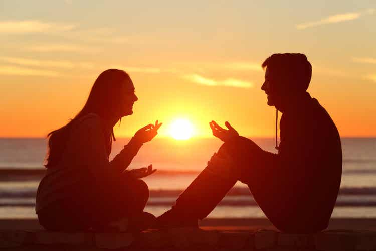 Coppia parla al tramonto delle emozioni sociali.