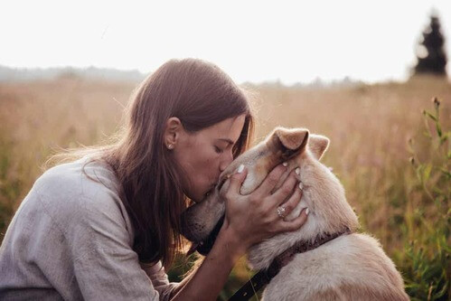 Donna che bacia il suo cane.