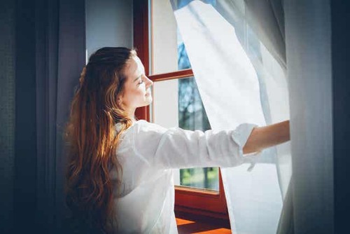 Donna che apre una finestra