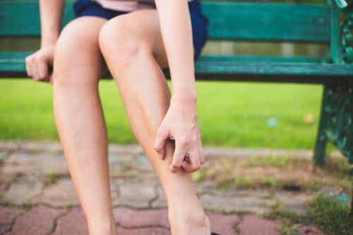 Donna che si gratta le gambe perché ha prurito.