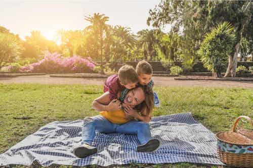 Madre e figli che fanno un picnic e si divertono.