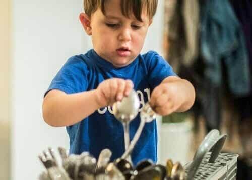 Bambino che pulisce le posate.